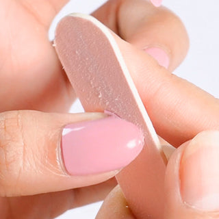 Using a nail file to trim and smooth EyeCandys Gel Nail Stickers for a salon-quality, custom-fit nail design