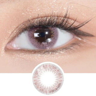 A close-up of an eye with long lashes, shimmering eyeshadow, and EyeCandys Attitude Glitter Pink contacts. Below is a circular image of the lens design—ideal for those seeking comfortable, high water content EyeCandys contacts.