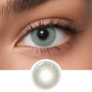 A close-up of a person's eye wearing EyeCandys Aura Crystal Grey contacts, with a circular inset at the bottom showing a detailed view of the UV blocking lens design.
