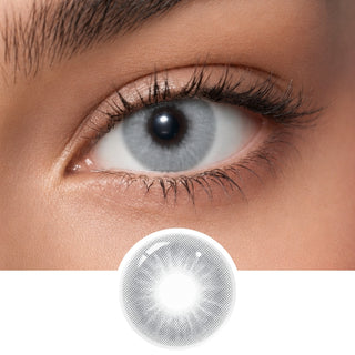 A close-up of an eye wearing EyeCandys Aura Olive Grey contact lenses by EyeCandys; below is a detailed image of the lens, showcasing its natural olive grey color pattern and transparency.