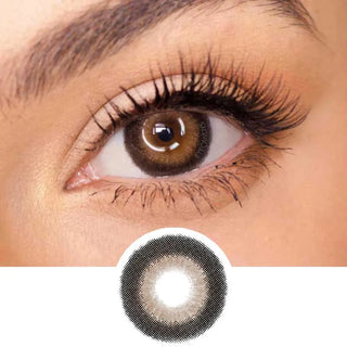 A close-up of a brown eye with long lashes wearing EyeCandys Pink Label Big Ring Brown lenses. Below, an enlarged image displays the lens’s unique doll-like pattern and its eye-enlarging effect.