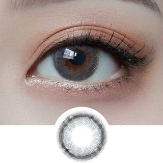 A close-up of an eye wearing Molak 1-Day Bubble Blue (10pk) contact lenses by Molak, which subtly enlarge the iris; below the eye is the lens pattern in black and white. The makeup features natural, subtle tones.