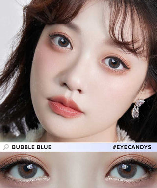 A close-up of a fair-skinned woman with soft makeup and wavy dark brown hair wearing Molak 1-Day Bubble Blue (10pk) color contacts. An inset highlights her vibrant eyes. Text reads: "Bubble Blue #EYECANDYS." Brand: Molak.