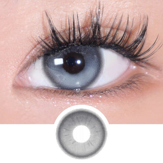 A close-up of an eye wearing EyeCandys Bunnie Milky Ash Grey lenses shows long lashes. Below, an enlarged image highlights the EyeCandys lens' glowy ash grey pattern and detailed design.