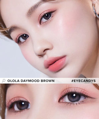 Close-up of a person with flawless skin, soft pink makeup, and light grey contact lenses for myopia prescription. The image highlights the eyes and makeup, with the text "OLOLA DAYMOOD GREY #EYECANDYS" across the photo.