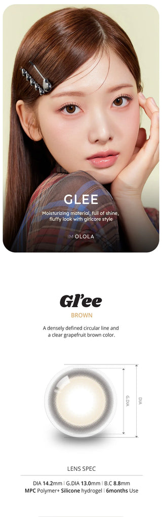 A young woman with straight, light brown hair and a silver hairpin wears Olola Glee Brown by Olola, ideal for dark eyes. Close-up: diameter 14.2mm, base curve 8.8mm, usable for 6 months.