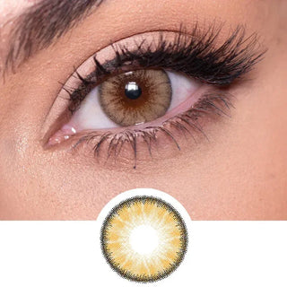 Close-up shot of a model eye wearing Desire Toffee Brown colored contact lens in one eye that is naturally dark-brown with natural rosegold eye make up