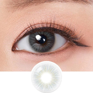 A close-up of a person’s eye wearing Olola Heiress Grey by Olola, color contact lenses ideal for dark eyes, with a circular insert below showing a detailed view of the lens design.