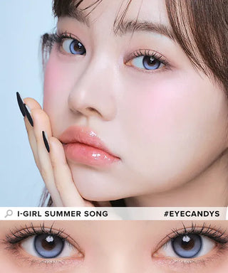 A close-up of a woman with soft makeup and glossy lips, gently touching her face. The lower part highlights her i-Girl One Pick Balance Summer Song Blue contacts. Text reads "i-Girl SUMMER SONG #EYECANDYS.