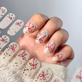 A close-up of a model's hand holding the EyeCandys Knot Yours Gel Nail Stickers, featuring the stylish and intricate knot design. Ideal for Valentine’s Day nails, February nails, and minimalist nail inspo, this design offers a chic, modern twist to your manicure, perfect for those who love subtle yet trendy nail art