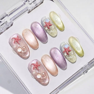 EyeCandys Mermaid on Duty press on nails featuring iridescent cat eye glitter nails in rose, champagne, lavender, silver, and chartreuse with 3D starfish and pearl accents.