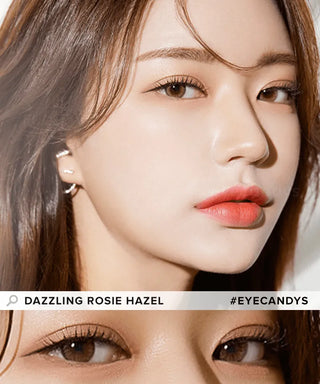 Close-up of a woman with fair skin, glossy coral lips, and light brown eyes wearing Olola Dazzling 1-Day Rosie Hazel (10pk) color contacts by Olola. She has long brown hair and looks slightly to the side. Text: “DAZZLING ROSIE HAZEL #EYECANDYS.”.