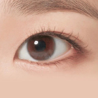 Close-up of a right eye with brown iris and natural lashes, wearing NEO Vision Neoism Super Clear (50pk) contact lens, with part of the eyebrow and smooth skin visible.