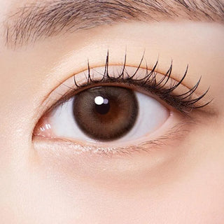 Macro shot of an eye wearing the Olola Muted Choco prescription colour contact lens, showing the multi-colored detail and natural effect on dark brown eyes.