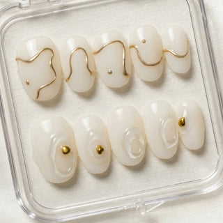 Designer press on nails Gilt Lines with creamy white base, bold 3D sculptural details, and metallic gold line accents for an expensive custom nail look.