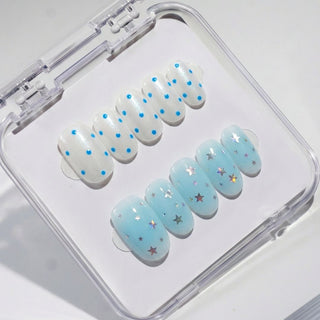 Short oval press on nails EyeCandys Plot Twist with split design nails, blue polka dots, jelly blue base, and holographic star confetti accents.