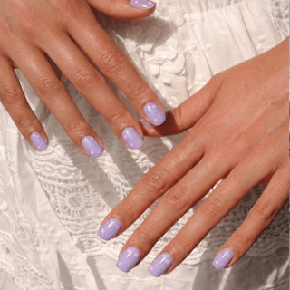 Hand wearing EyeCandys Stardust Baby press on nails featuring lavender jelly nails with pink star sequins and confetti accents.