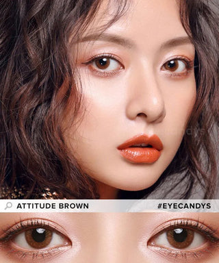 A woman with wavy brown hair and warm makeup gazes ahead. Her brown eyes, shown in a close-up labeled "EyeCandys Attitude Glitter Brown," feature natural colored contacts by EyeCandys for a subtle, authentic look.