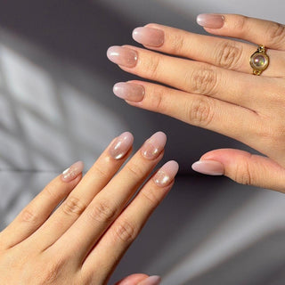Hand wearing EyeCandys Bloom n Fade press on nails featuring champagne cat-eye nails fading into soft petal pink gradient tips.