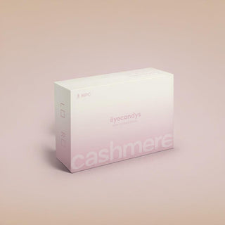 A white and pale pink box labeled "eyecandys" and "cashmere," designed for contact lenses, sits on a light beige background. The box also displays "MPC" and "L" and "R" indicators on the side.
