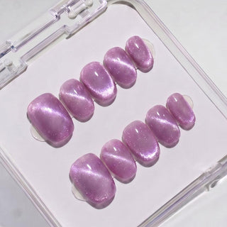 EyeCandys Grape Jelly press on nails featuring dusty mauve-purple jelly nails with iridescent pink and gold shimmer in a short round shape.