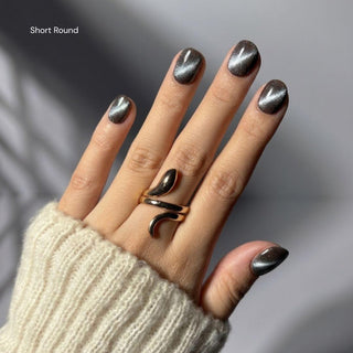 Hand wearing EyeCandys Grapefruit Soda short round press on nails featuring semi-sheer pink cat-eye nails with soft grapefruit gradient tips.
