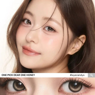 Close-up of model’s eyes wearing i-Girl One Pick Dear One Honey contact lenses from EyeCandys, showing warm honey-brown iris color, realistic highlights, weighted non-rotating design, and subtle eye-widening effect