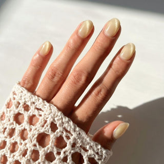 Hand wearing EyeCandys Lemon Drops press on nails featuring warm golden yellow cat-eye nails with glossy pearlescent shimmer.