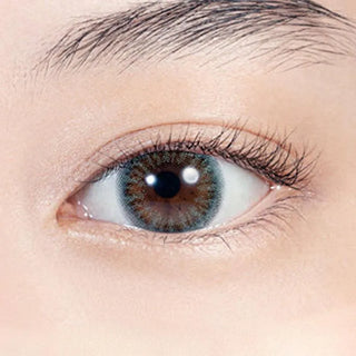 Close-up shot of model's eye adorned with Lilmoon Monthly Ocean (Prescription) color contact lenses with prescription, complemented by minimalist eye makeup, showing the brightening and enlarging effect of the circle contact lens on dark brown eyes.