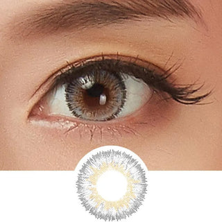 Close-up of a brown eye with long lashes, wearing NEO Vision Glamour Grey (Custom Toric for Astigmatism) contacts featuring a patterned gray and gold ring; the lens design is shown below the eye.