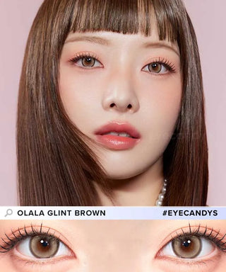 A woman with straight brown hair and natural makeup wears Olola Glint 1-Day Brown (10pk) circle lenses by Olola. A close-up shows the subtle, natural brown color. Text reads "OLALA GLINT BROWN #EYECANDYS".
