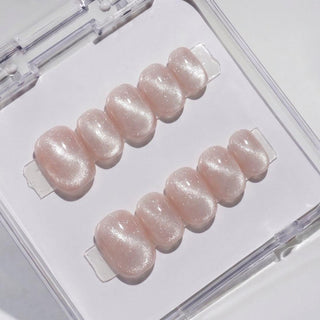EyeCandys Pink Noise press on nails featuring soft blush pink cat-eye nails with pearlescent shimmer and glossy finish in a short round shape.