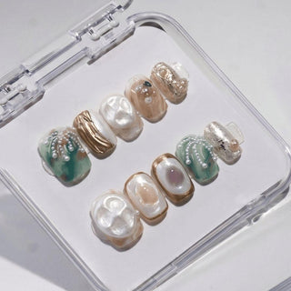 EyeCandys Shell We press on nails featuring sculptural mother of pearl nails in cream sage and sand with pearl beads and gold brushstroke details.