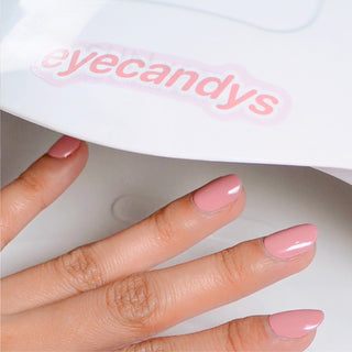 Using a UV light lamp to cure EyeCandys Gel Nail Stickers for perfect adhesion, smooth finish, and a glossy, gel-like manicure that lasts