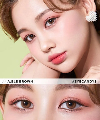 A woman with fair skin and soft pink makeup poses, her brown eyes captivating the viewer. She wears Olola Able Brown lenses by Olola, enhanced with subtle eyeliner. The lower part features a close-up of her eyes.