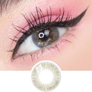 A close-up of an eye with dramatic black eyeliner, long lashes, pink eyeshadow, and glitter, wearing EyeCandys Attitude Glitter Grey colored contacts by EyeCandys with a subtle gold and brown pattern shown in detail below.
