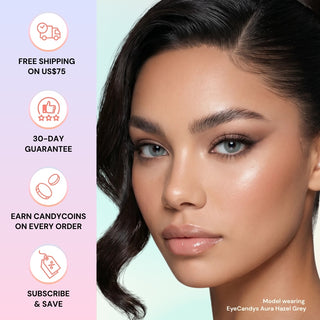 A woman with smooth skin and striking EyeCandys Aura Hazel Grey contacts poses with soft makeup. Icons beside her highlight free shipping over $75, a 30-day guarantee, CandyCoins rewards, and subscribe & save offers from EyeCandys.