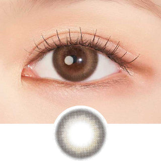 A close-up of a brown eye with long lashes wearing Clalen IRIS Canola Brown (10pk) contacts by Clalen, which enhance the iris color. Below is a circular image highlighting the unique design of these prescription lenses.