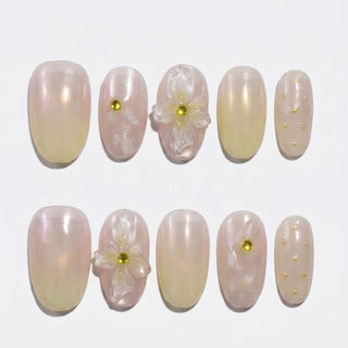 The Daisy Does It Press-On Nails by EyeCandys features ten handmade nails with a pearly pink and gold gradient, 3D white flowers with gold centers, gold studs, and dots—perfect for an elegant spring-inspired manicure.
