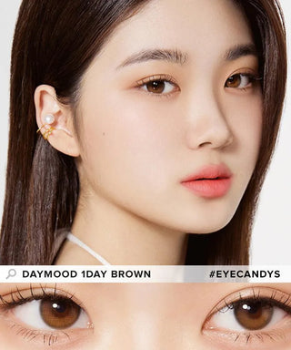 A close-up shows a woman with straight brown hair, clear skin, and natural makeup wearing Olola Daymood 1-Day Brown (10pk) lenses. Below is a zoom of her brown eyes. Text: "Olola Daymood 1-Day Brown" and "#EYECANDYS".