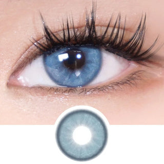 A close-up of a human eye with long lashes, wearing EyeCandys Doe Blue colored contacts with a natural iris design. Below is an enlarged image of the lens from EyeCandys, showcasing its detailed pattern.