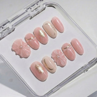 Short oval press on nails EyeCandys En Rose with soft blush pink tones, sheer ivory accent nail, 3D floral nail art, and micro pearl detailing.