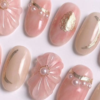 EyeCandys En Rose press on nails featuring blush pink and ivory base with sculpted 3D translucent flower, pearl center, gold rose embossment, and curved French tip details.