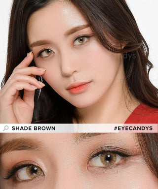 A woman with long dark hair poses, wearing natural makeup and EyeCandys Shade Brown contact lenses. A close-up highlights her light brown eyes and soft eyeshadow. Text reads "SHADE BROWN" and "#EYECANDYS.