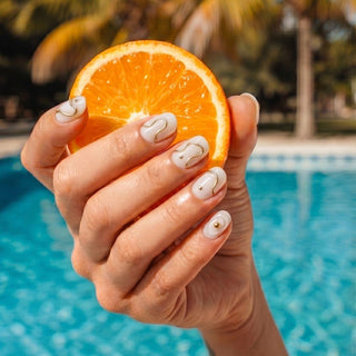 Hand wearing reusable Gilt Lines press on nails featuring sculpted white texture and metallic gold accents for a clean, modern luxury manicure.
