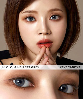 A woman with short brown hair and light skin gazes ahead, wearing Olola Heiress Grey color contact lenses for myopia. A close-up below highlights these Olola colored contacts for dark eyes. Text reads "OLOLA HEIRESS GREY #EYECANDYS".
