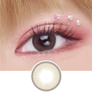 A close-up of an eye with long lashes, pink eyeshadow, and rhinestones features the EyeCandys Pink Label Barcelona Brown contact lens. Below the eye is an image of this comfortable colored lens design.