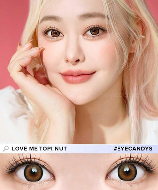 A fair-skinned, platinum blonde woman smiles gently, resting her face on her hand. She wears i-Sha Dekame Love Me Toffeenut Brown colored contacts by i-Sha, Japanese lenses with a subtle limbal ring effect.