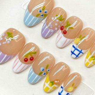 EyeCandys Macedonia Press-On Nails feature pastel fruit and stripe designs—cherries, grapes, lemons, and blue accents on a nude base—giving you glossy, salon-quality summer nail art in a playful gel-look finish.