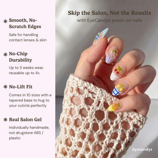 A hand with vibrant floral and fruit Macedonia Press-On Nails by EyeCandys holds a cream crochet fabric. Text highlights smooth edges, no-chip durability, no-lift fit, and real salon gel for premium handmade press-on nails.
